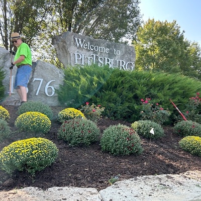 Volunteers planting mums at 20th & the Bypass Welcome sign.