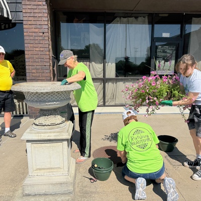 Ned Johnson, Sharon Johnson, Pam Walker, and Heaven Jones planting petunias in urns.