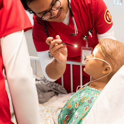 Nursing students care for a simulation patient.